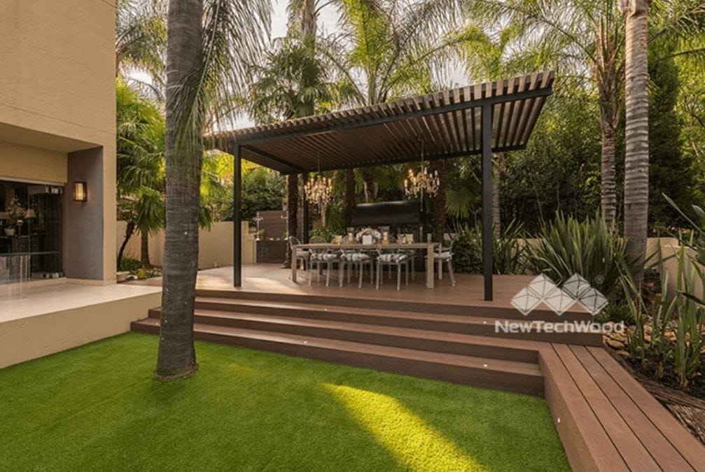 Composite deck steps and pergola beside a landscaped lawn