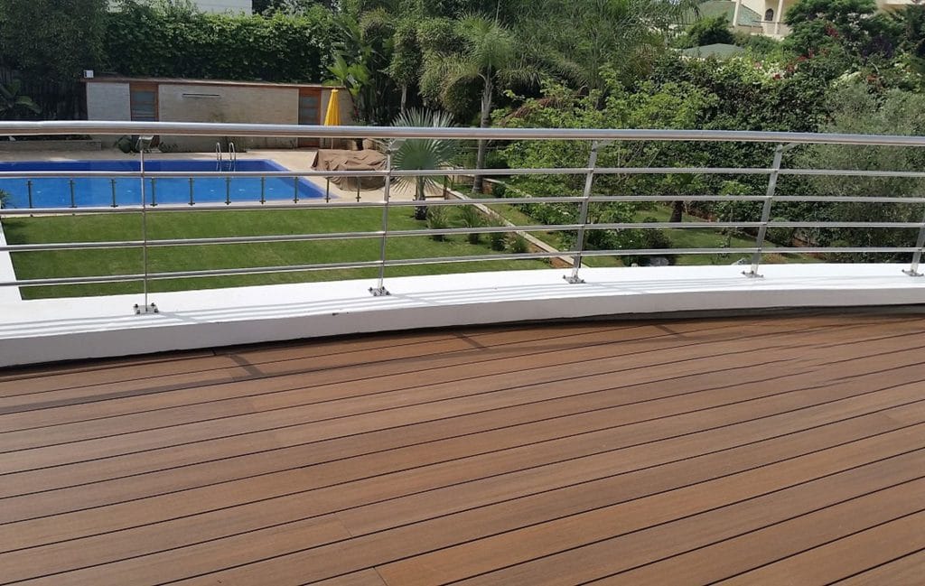 Glass and metal railing above a pool deck