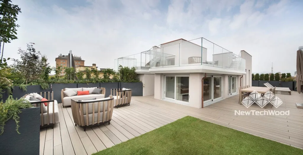 White villa with a deck opening onto the lawn